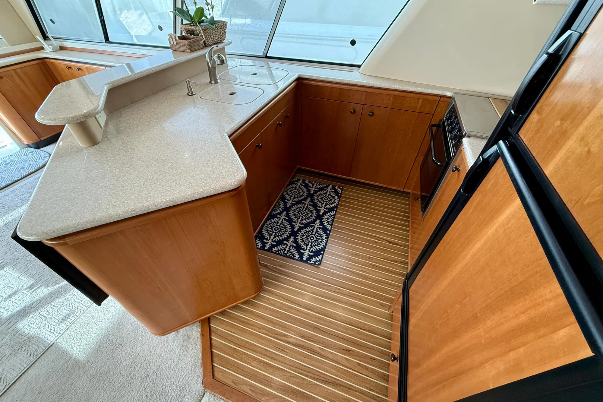 Luxurious 2004 Meridian 490 Pilothouse kitchen with wood cabinetry and modern appliances.