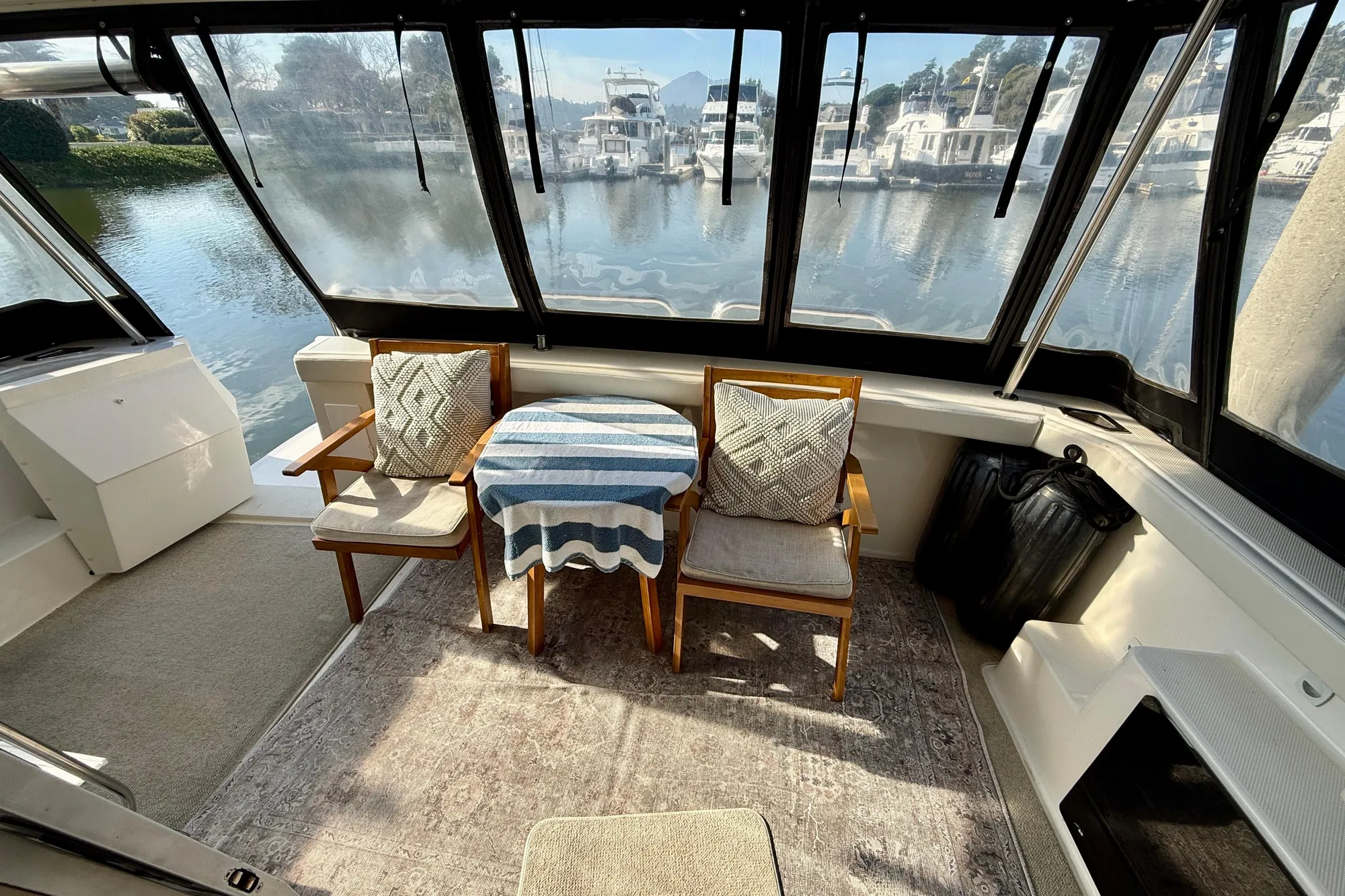 Interior of 2004 Meridian 490 Pilothouse with chairs and table, overlooking marina.