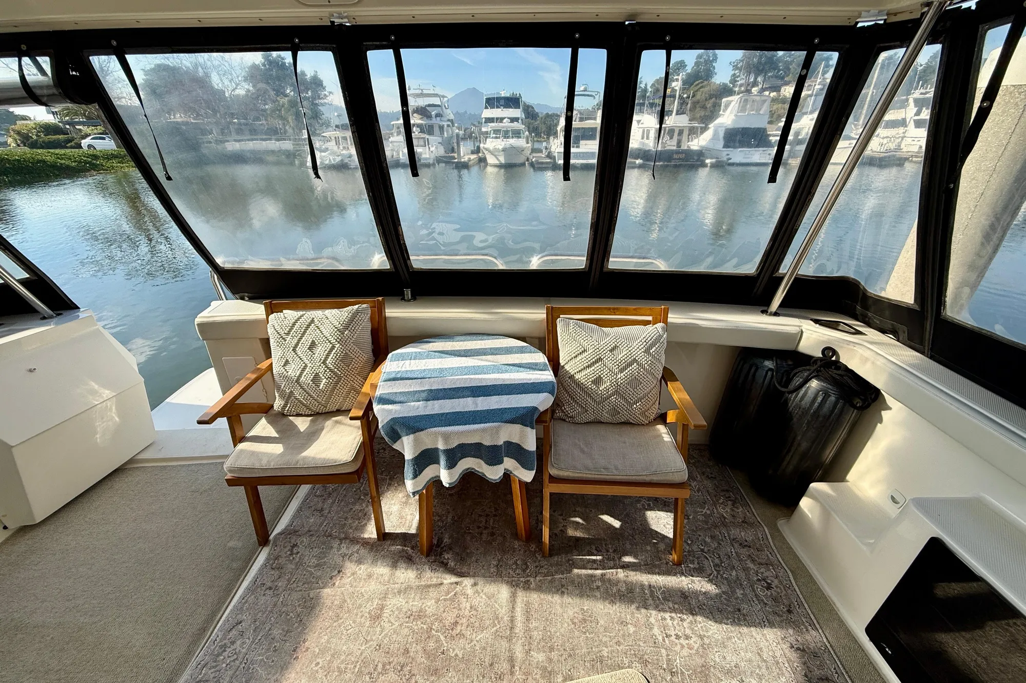 Interior of 2004 Meridian 490 Pilothouse with chairs and table overlooking marina.