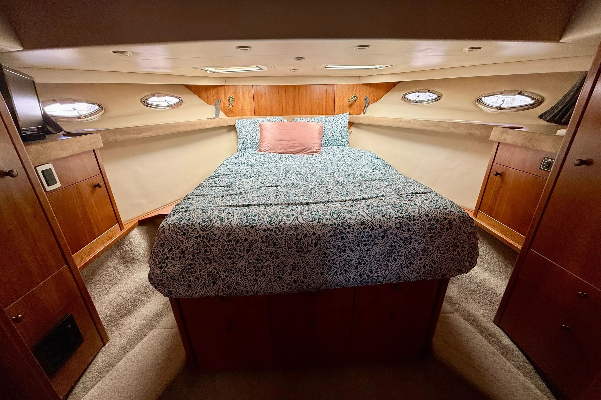 Luxurious bedroom interior of 2004 Meridian 490 Pilothouse yacht with elegant wood finish.