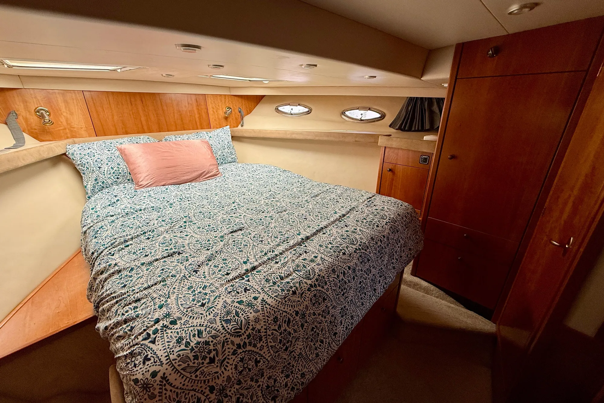 Luxurious bedroom in 2004 Meridian 490 Pilothouse yacht with elegant wood finishes.