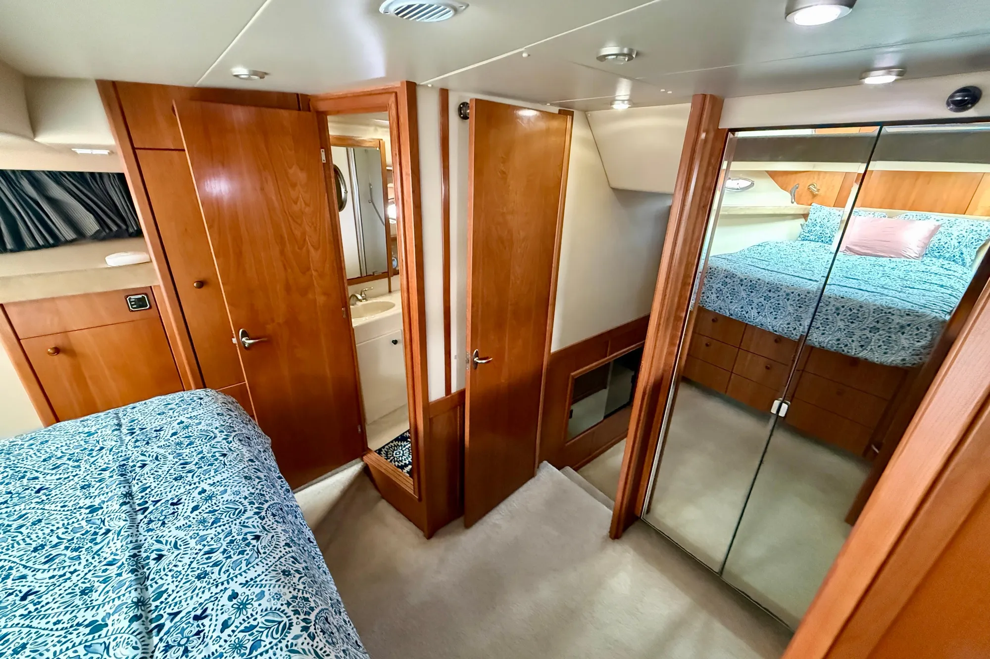 Luxurious 2004 Meridian 490 Pilothouse interior with wood finishes and cozy bedding.