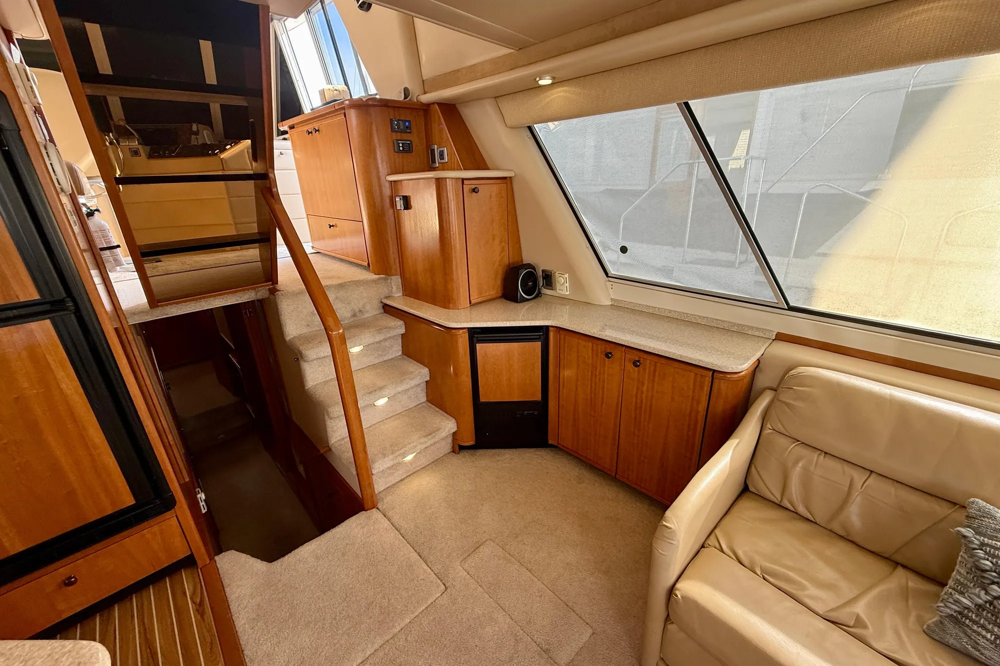 Interior of 2004 Meridian 490 Pilothouse yacht with wood cabinetry and beige seating.