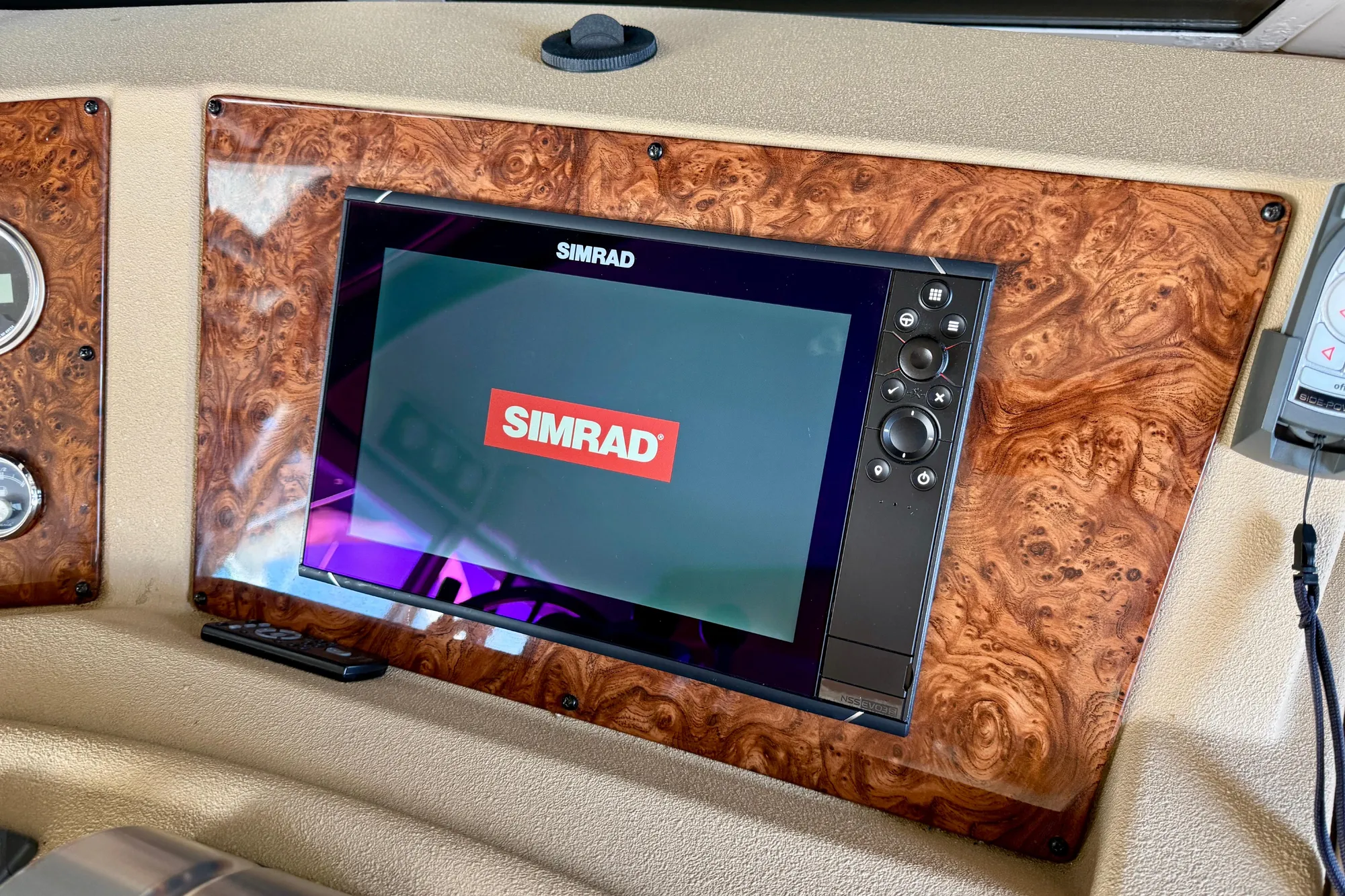 Simrad display on 2004 Meridian 490 Pilothouse dashboard with wood paneling.