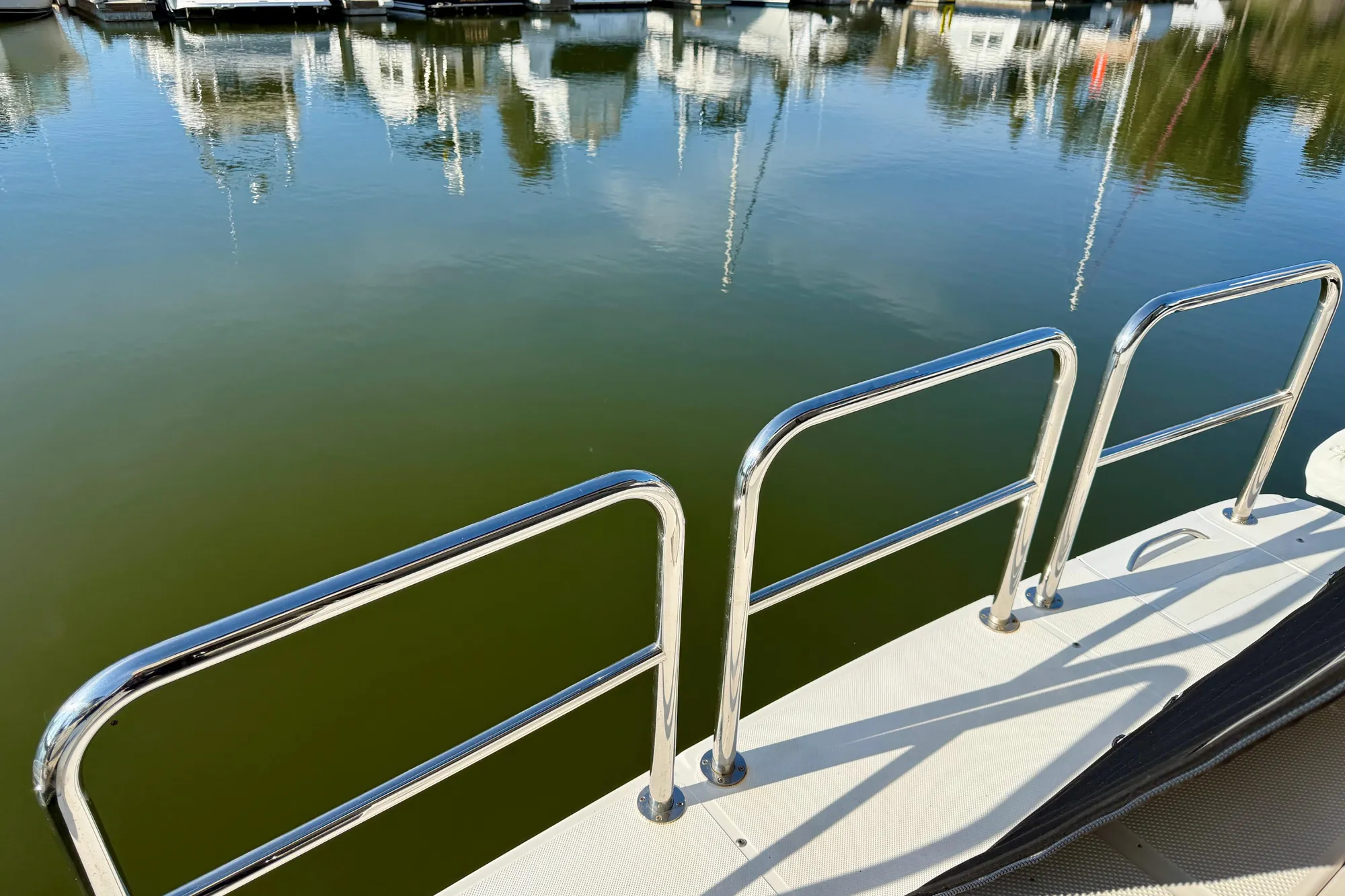 2004 Meridian 490 Pilothouse boat deck with stainless steel railings by calm marina.