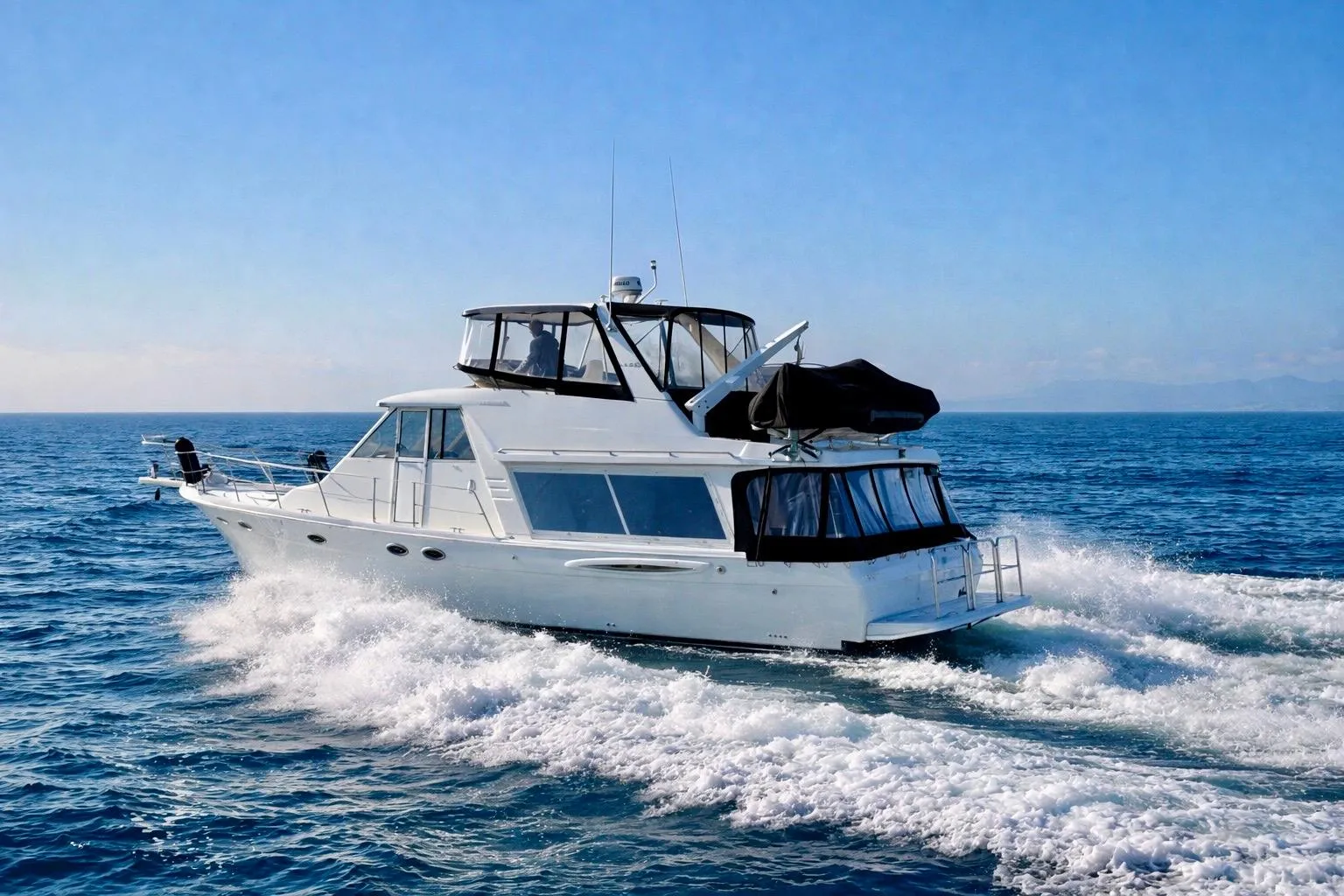 2004 Meridian 490 Pilothouse yacht cruising on open sea under clear blue sky.