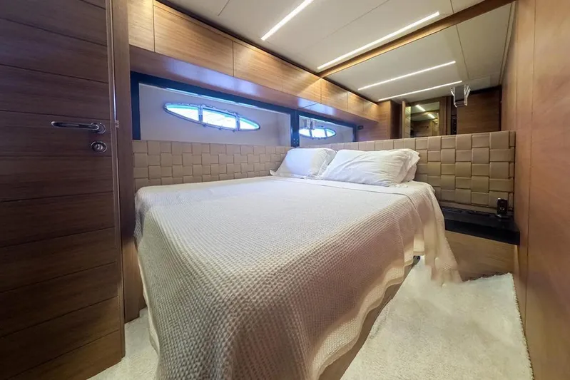 Honey Badger Yacht Photos Pics Luxurious bedroom interior of 2012 Pershing 92 yacht with modern wood paneling.
