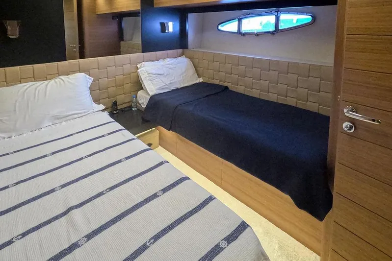 Honey Badger Yacht Photos Pics Luxurious cabin interior of 2012 Pershing 92 yacht with twin beds and porthole window.