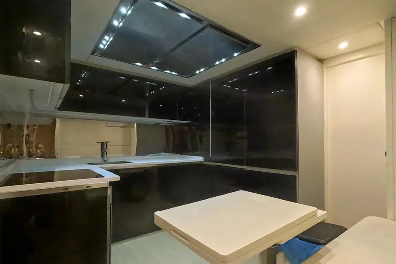 Honey Badger Yacht Photos Pics Modern kitchen interior of 2012 Pershing 92 yacht with sleek black cabinetry.