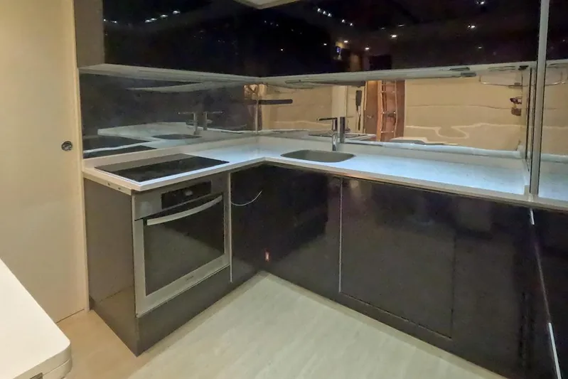 Honey Badger Yacht Photos Pics Modern kitchen interior on a 2012 Pershing 92 yacht, featuring sleek black cabinetry.