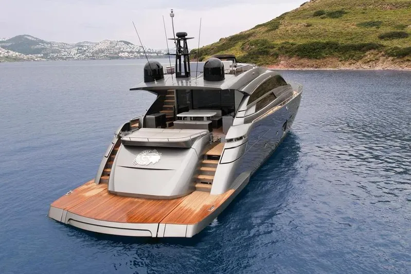 Honey Badger Yacht Photos Pics Luxury 2012 Pershing 92 yacht on serene blue waters near a lush coastline.