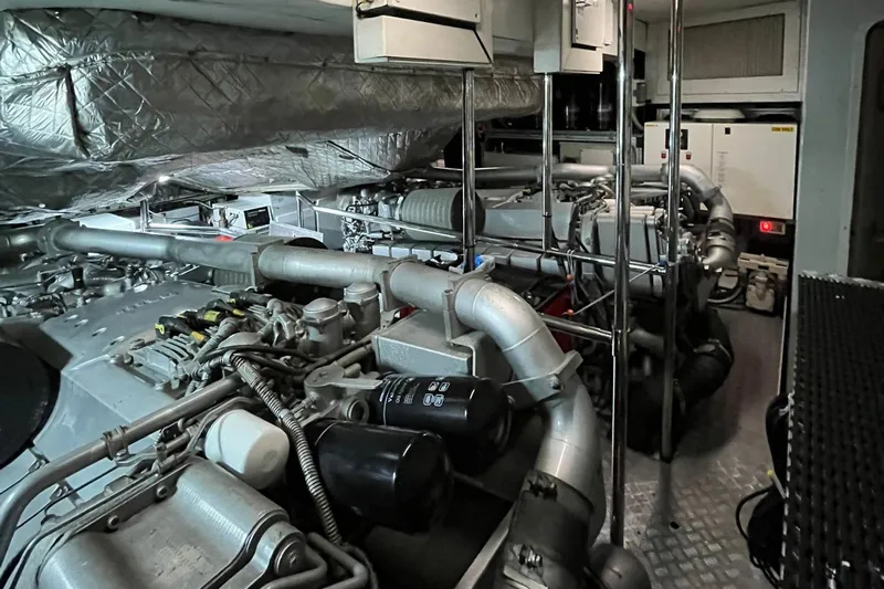 Honey Badger Yacht Photos Pics Engine room of a 2012 Pershing 92 yacht, showcasing complex machinery and piping.