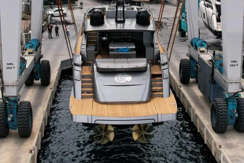 Honey Badger Yacht Photos Pics 2012 Pershing 92 yacht being lifted by a crane at a dock.