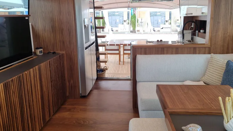 Panta Rei Yacht Photos Pics Interior of 2022 Monachus 70 Fly yacht with modern wood finishes and cozy seating area.