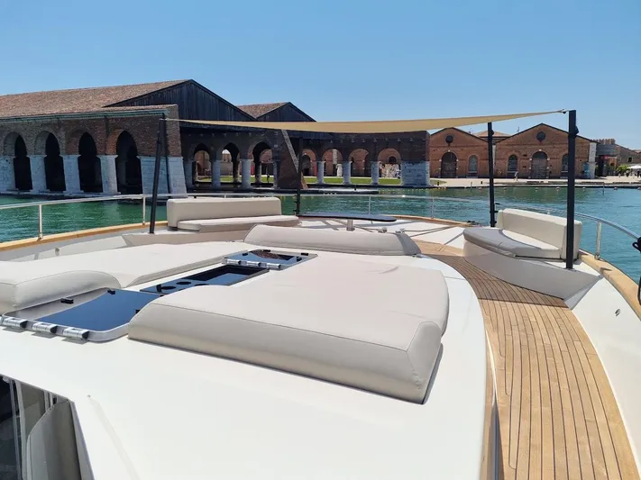 Panta Rei Yacht Photos Pics Luxurious Monachus 70 Fly yacht deck with sun loungers, 2022 model, near historic waterfront buildings.