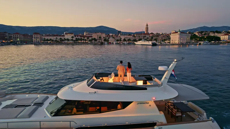 Panta Rei Yacht Photos Pics Couple enjoying sunset on Monachus 70 Fly yacht, 2022, overlooking coastal cityscape.