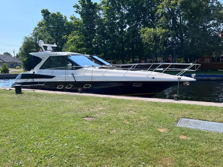Rough Play Yacht Photos Pics 2010 Regal 600 Express yacht docked by a grassy shore, surrounded by trees.