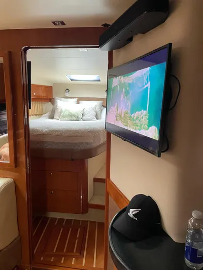 Rough Play Yacht Photos Pics Interior of 2010 Regal 600 Express yacht with cozy bedroom and mounted TV.