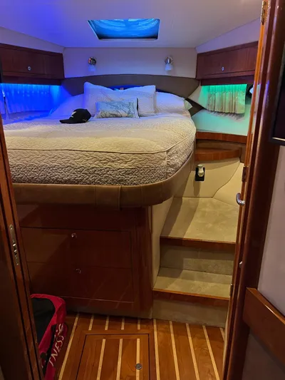 Rough Play Yacht Photos Pics Interior cabin of 2010 Regal 600 Express with bed, ambient lighting, and wooden flooring.