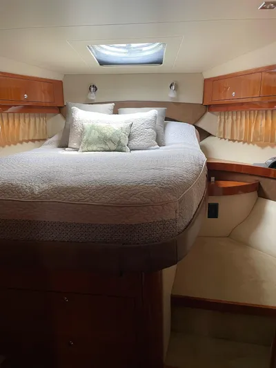 Rough Play Yacht Photos Pics Luxurious cabin interior of 2010 Regal 600 Express yacht with cozy bedding and elegant wood finishes.