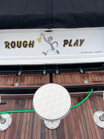 Rough Play Yacht Photos Pics 2010 Regal 600 Express boat with "Rough Play" graphic on wooden deck.