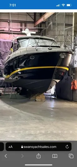 Rough Play Yacht Photos Pics 2010 Regal 600 Express yacht in storage, sleek design, black hull, yellow stripe.