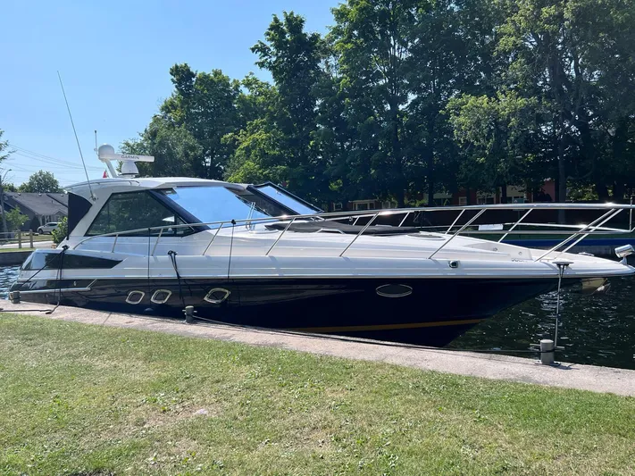 Rough Play Yacht Photos Pics 2010 Regal 600 Express yacht docked by a grassy shore, surrounded by trees.