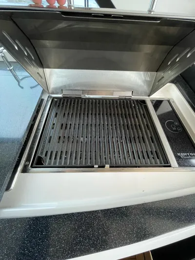 Rough Play Yacht Photos Pics Built-in grill on 2010 Regal 600 Express boat, open lid, sleek design.