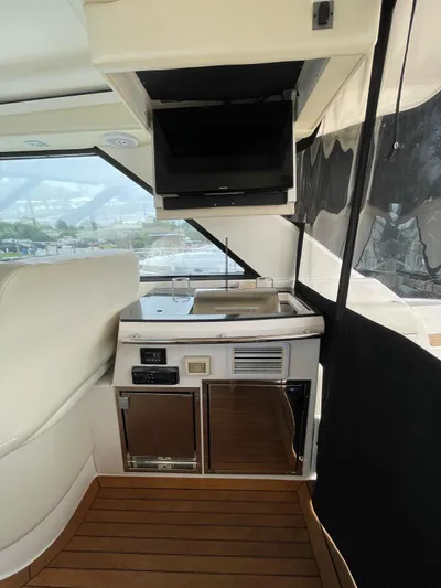 Rough Play Yacht Photos Pics 2010 Regal 600 Express yacht interior with kitchenette, TV, and wooden flooring.