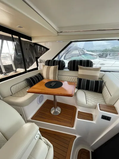 Rough Play Yacht Photos Pics Interior of 2010 Regal 600 Express yacht with elegant seating and wooden table.