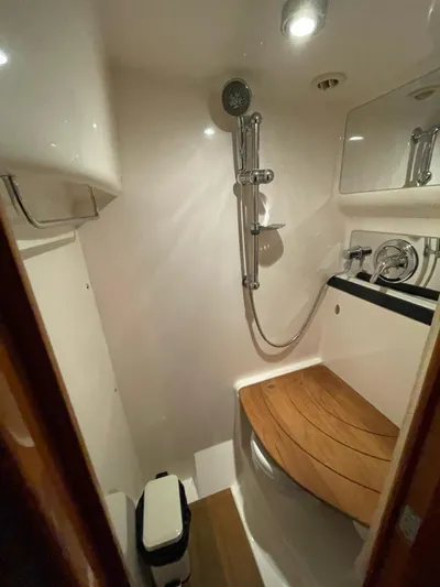 Rough Play Yacht Photos Pics Compact bathroom in 2010 Regal 600 Express boat with shower and wooden seat.
