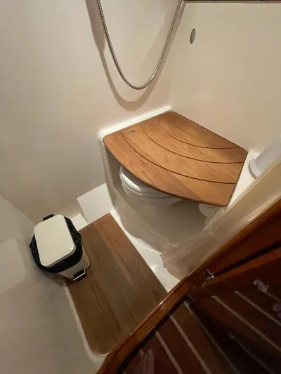 Rough Play Yacht Photos Pics 2010 Regal 600 Express bathroom with wooden seat cover and compact design.