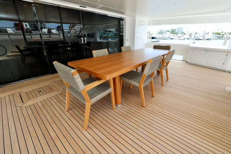  Yacht Photos Pics Elegant dining area on 2024 Rossinavi 49M Sport Yacht with wooden table and chairs.