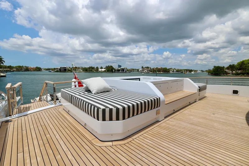  Yacht Photos Pics Luxurious deck of 2024 Rossinavi 49M Sport Yacht with striped sunbed and scenic water view.