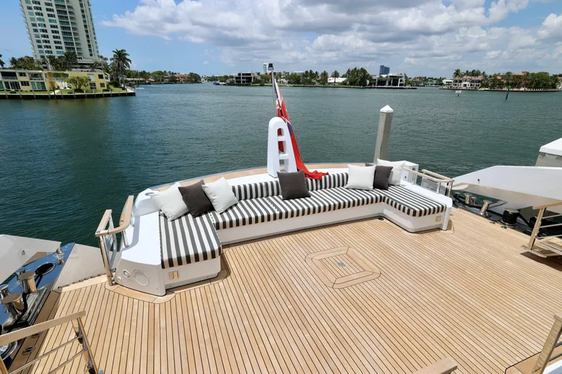  Yacht Photos Pics Luxurious deck of 2024 Rossinavi 49M Sport Yacht with striped seating and scenic waterfront view.