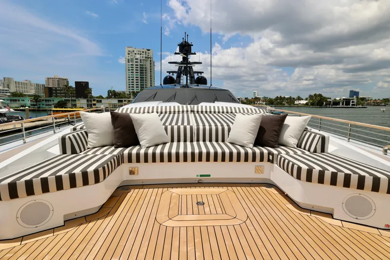  Yacht Photos Pics Luxurious 2024 Rossinavi 49M Sport Yacht with striped seating and scenic waterfront view.