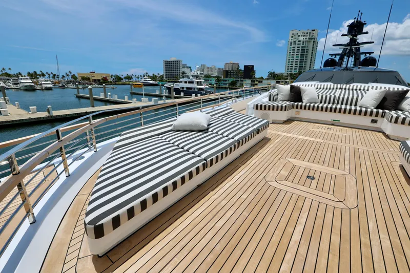  Yacht Photos Pics Luxurious 2024 Rossinavi 49M Sport Yacht deck with striped lounge seating in marina.