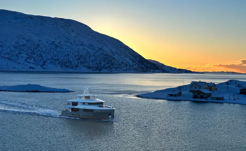 120 Discovery Yacht Photos Pics Luxury yacht Cheoy Lee 120 Discovery cruising at sunset in a serene, snowy landscape.