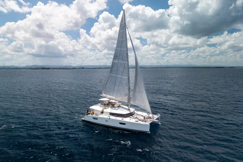  Yacht Photos Pics 2017 Fountaine Pajot Ipanema 58 sailing on open sea under a cloudy sky.