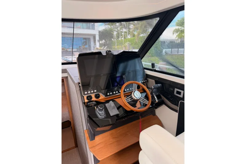  Yacht Photos Pics 2025 Tiara Yachts 48 LE helm with modern controls and wooden steering wheel.