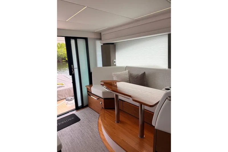  Yacht Photos Pics Interior of 2025 Tiara Yachts 48 LE, featuring elegant seating and wooden table.