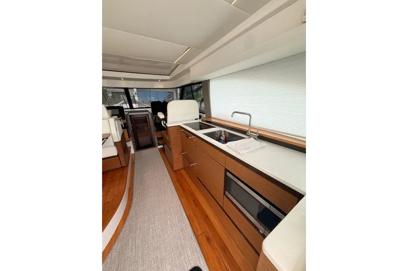  Yacht Photos Pics Luxurious interior of 2025 Tiara Yachts 48 LE, featuring modern kitchen and seating area.