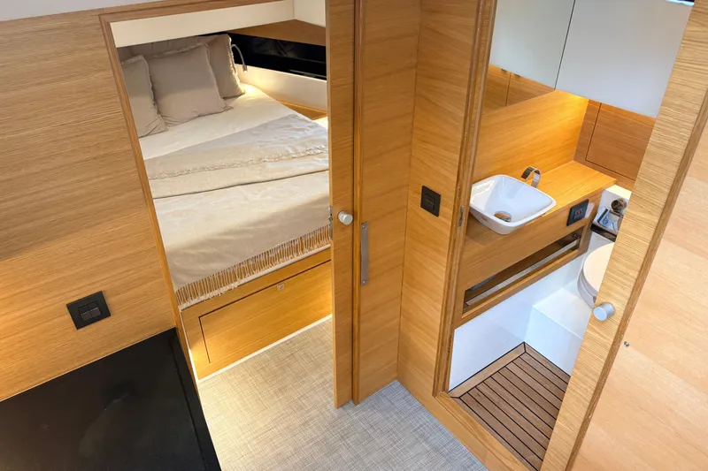 2025 De Antonio Yachts D42 @ Cancun Yacht Photos Pics Luxurious interior of 2025 De Antonio Yachts D42, featuring a cozy bedroom and modern bathroom.