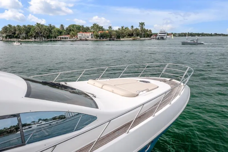  Yacht Photos Pics 2014 Azimut 64 Flybridge yacht cruising near a scenic shoreline.