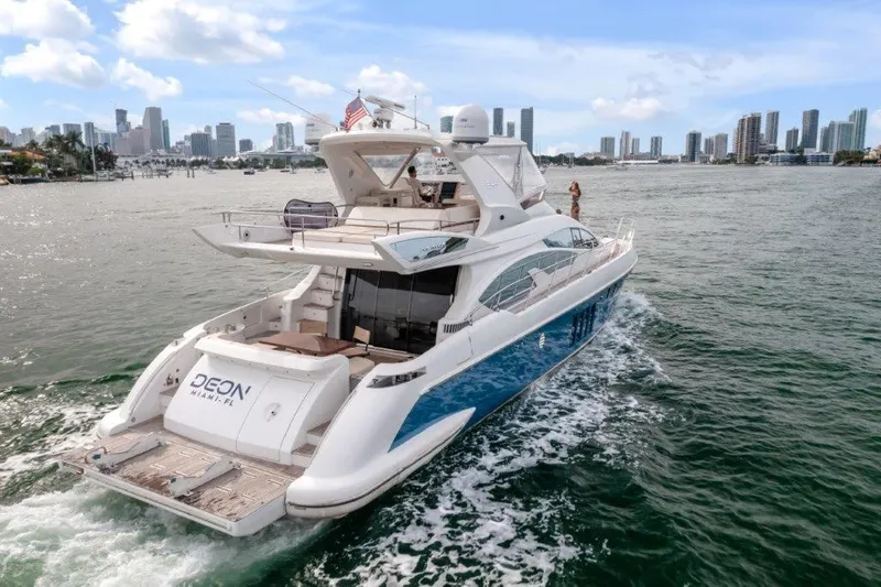  Yacht Photos Pics Azimut 64 Flybridge 2014 yacht cruising near city skyline on a sunny day.