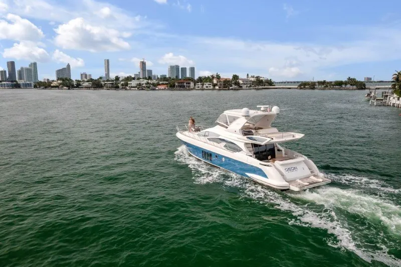  Yacht Photos Pics 2014 Azimut 64 Flybridge yacht cruising near city skyline on a sunny day.