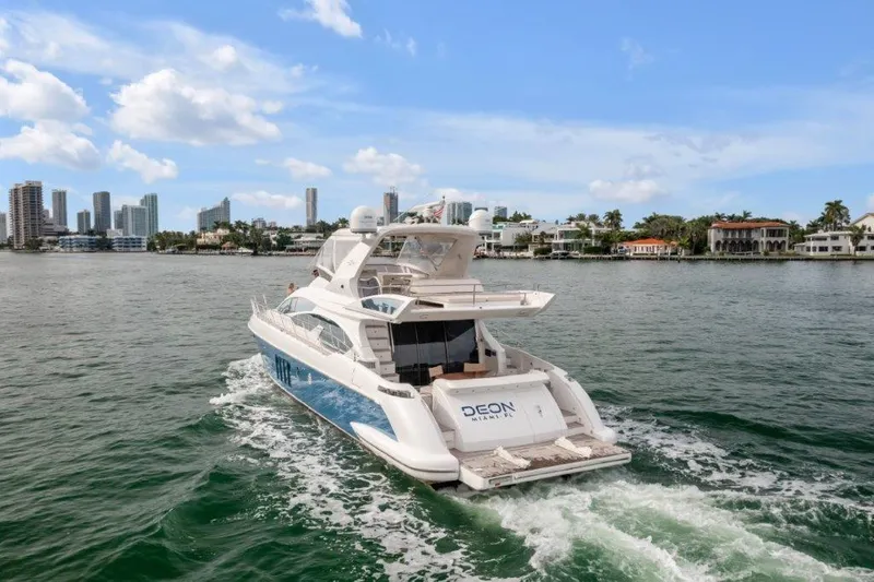  Yacht Photos Pics 2014 Azimut 64 Flybridge yacht cruising near city skyline and waterfront homes.