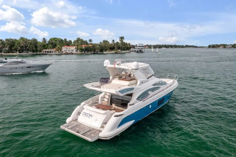  Yacht Photos Pics 2014 Azimut 64 Flybridge yacht cruising on a scenic waterway.