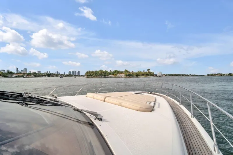  Yacht Photos Pics 2014 Azimut 64 Flybridge yacht cruising on a sunny day with city skyline in background.