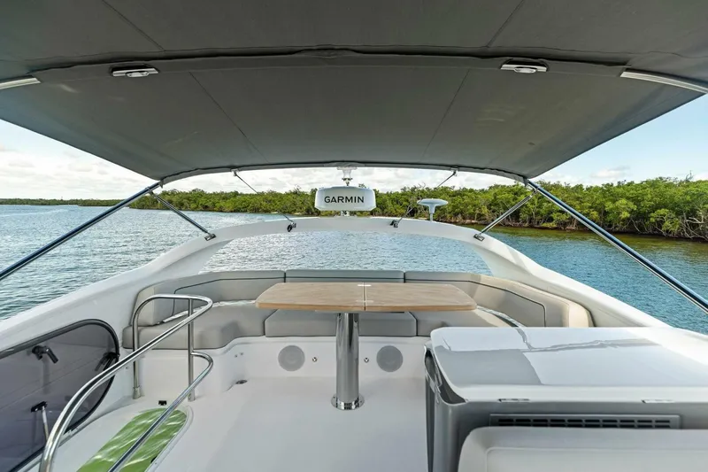 Twin Magic Yacht Photos Pics Luxury Princess F50 yacht interior with seating and table, cruising on a serene waterway, 2025 model.